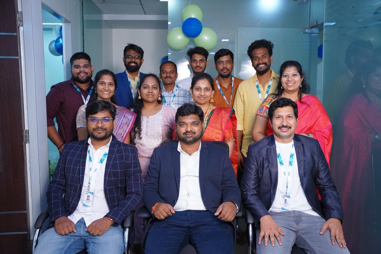 The team dressed formally for an office celebration with balloon decorations