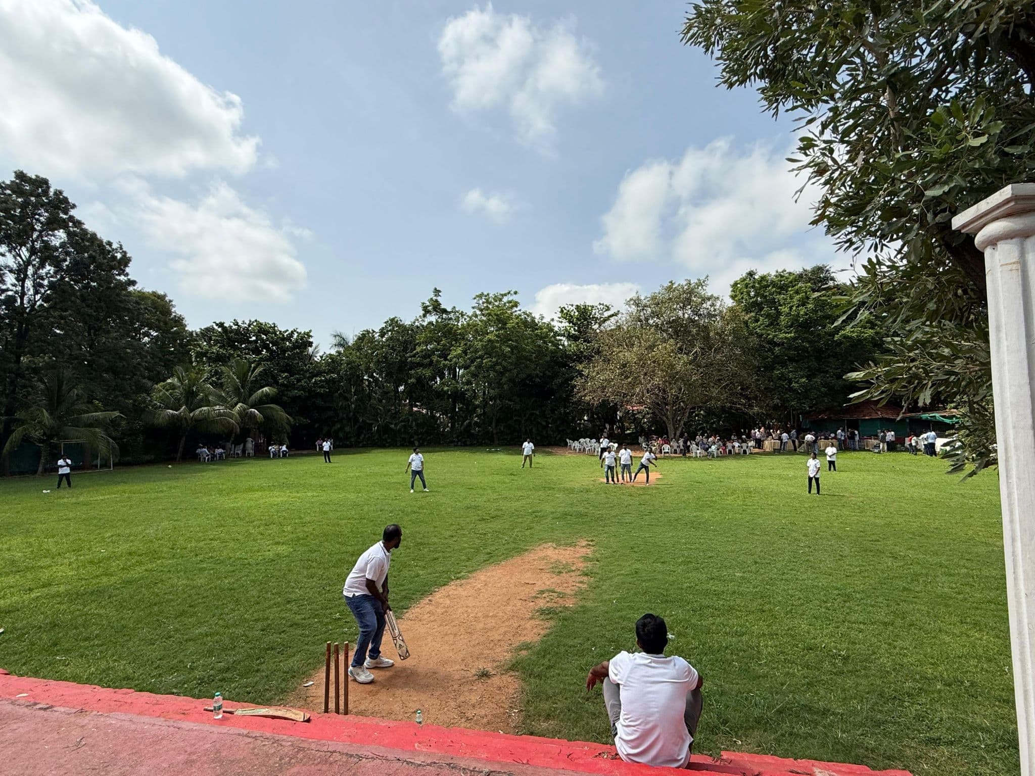 A team cricket match in progress on an open field
