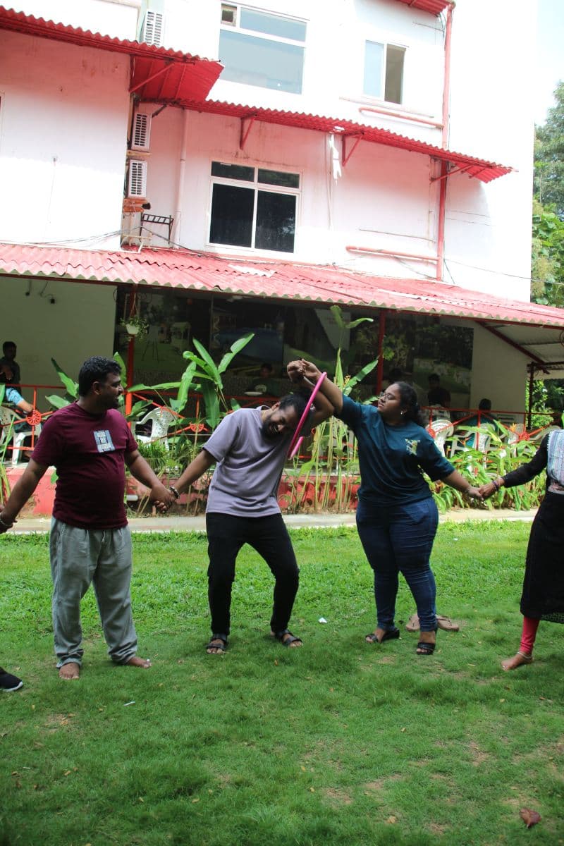 Colleagues laughing through a team game on the lawn