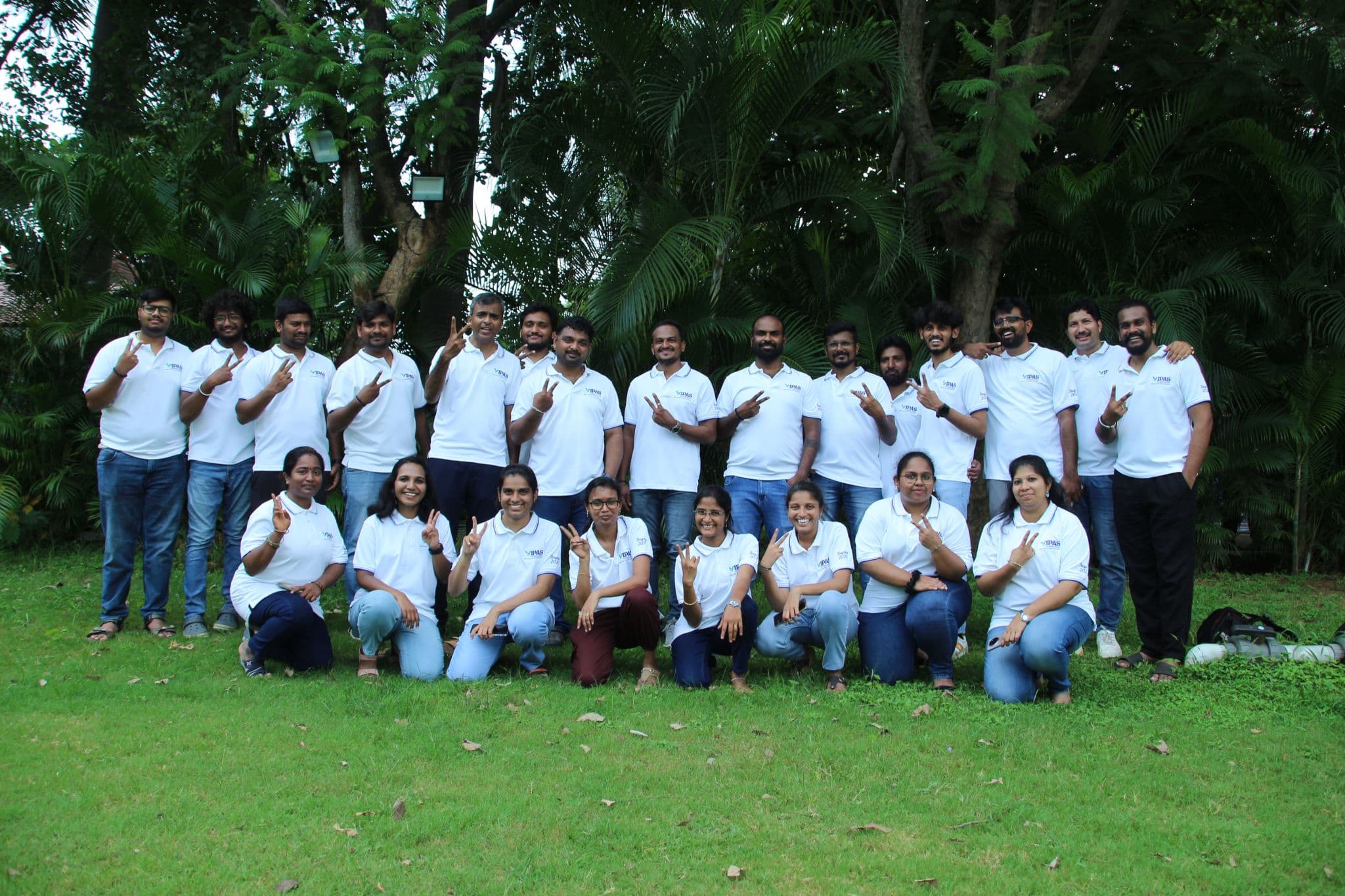 The whole team posing together in matching anniversary polo shirts