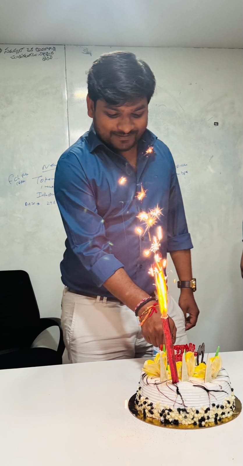 A colleague lighting a sparkler candle on a birthday cake