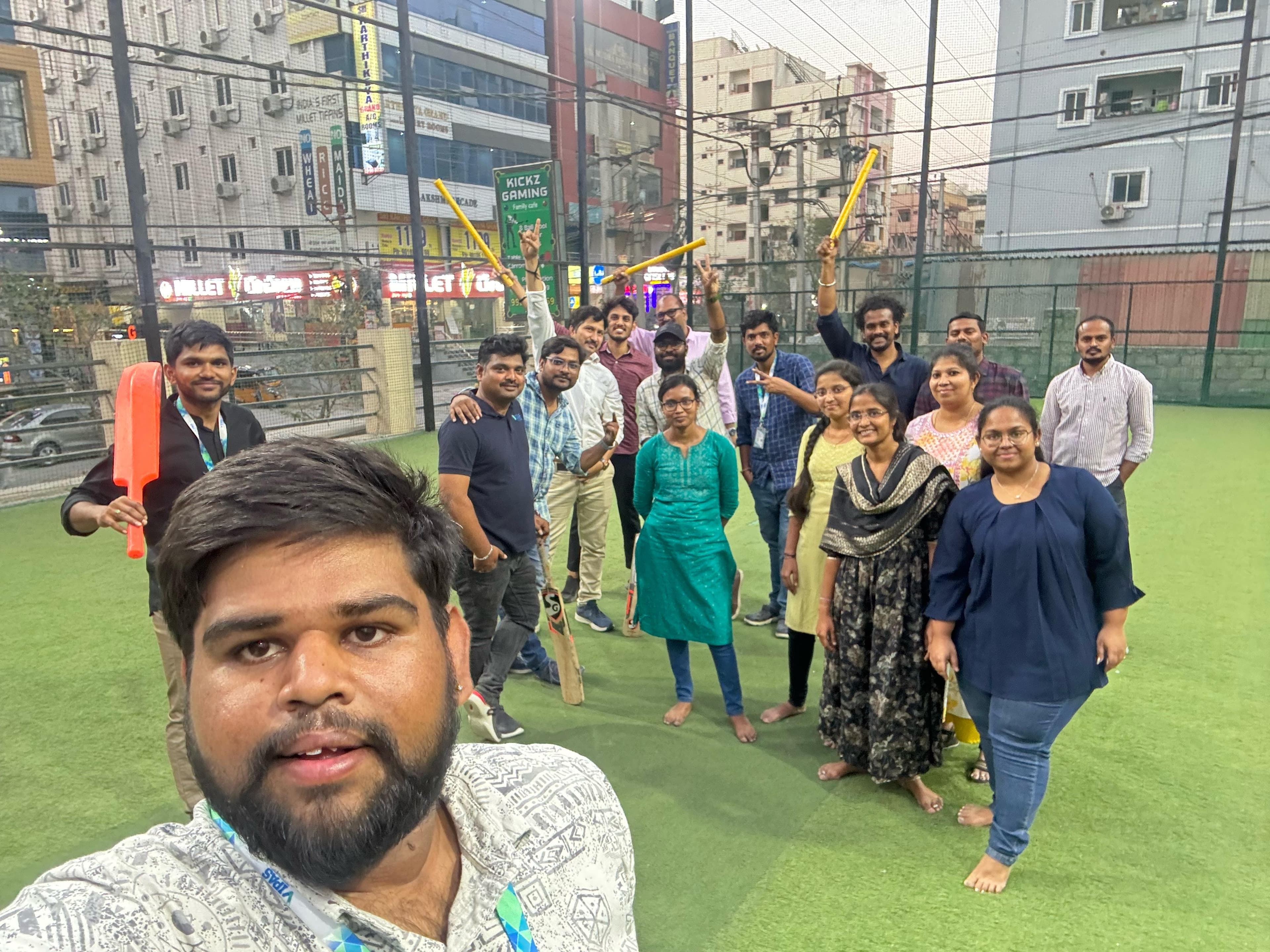 The Vipas team posing together with cricket bats and stumps at an indoor box cricket ground