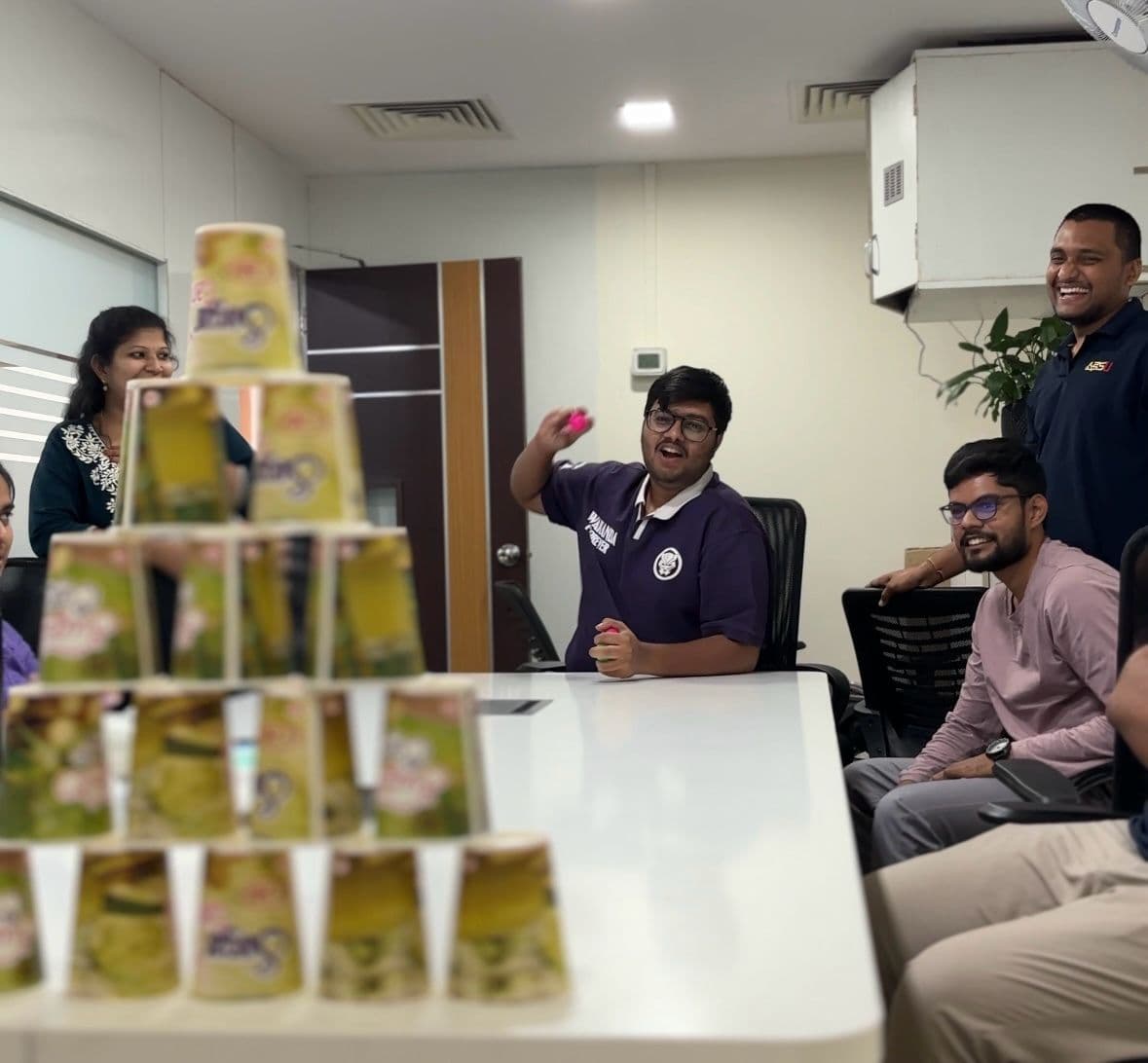 A colleague stacking cups in the office cup-tower game