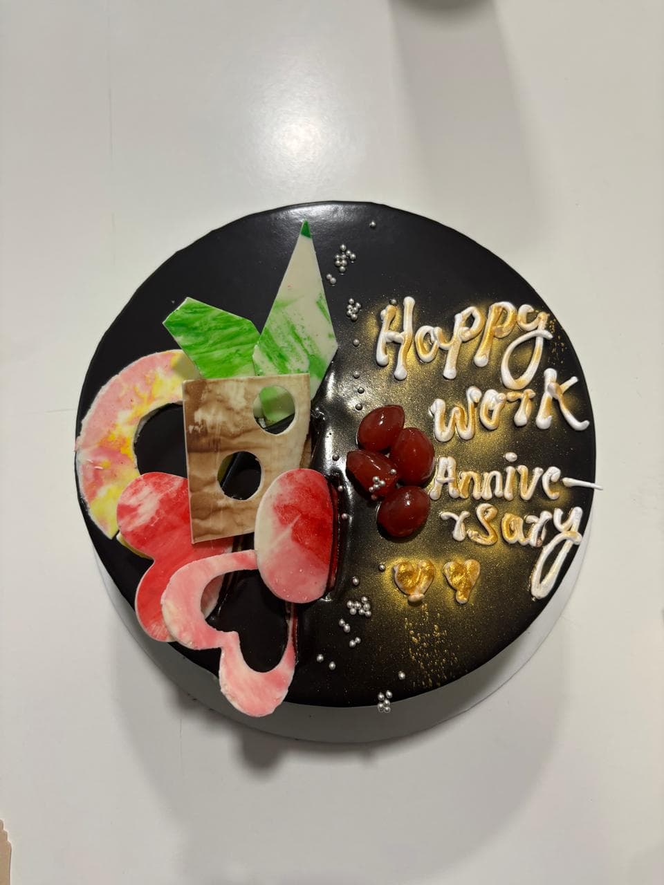 A cake decorated with a "Happy Work Anniversary" message in icing